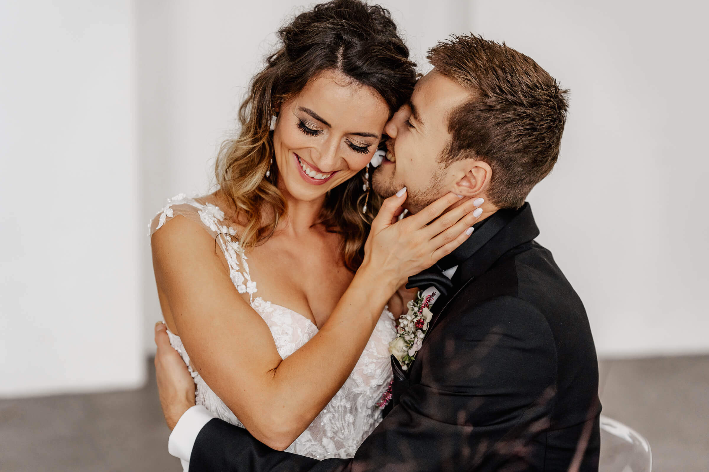 Bräutigam küsst Braut auf die Wange, Braut lächelt verliebt