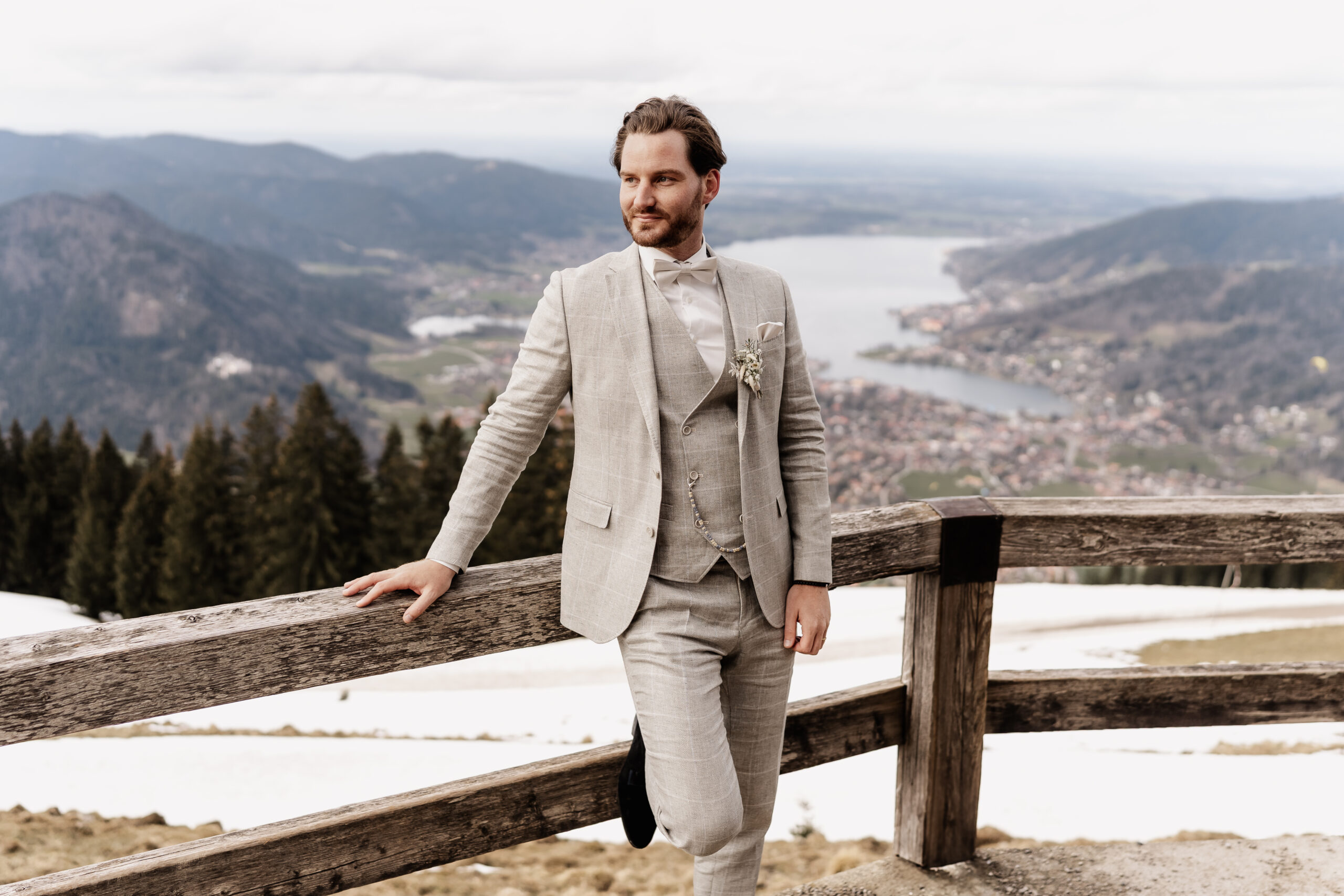 Eleganter Bräutigam wartet auf Braut, Tegernsee im Hintergrund