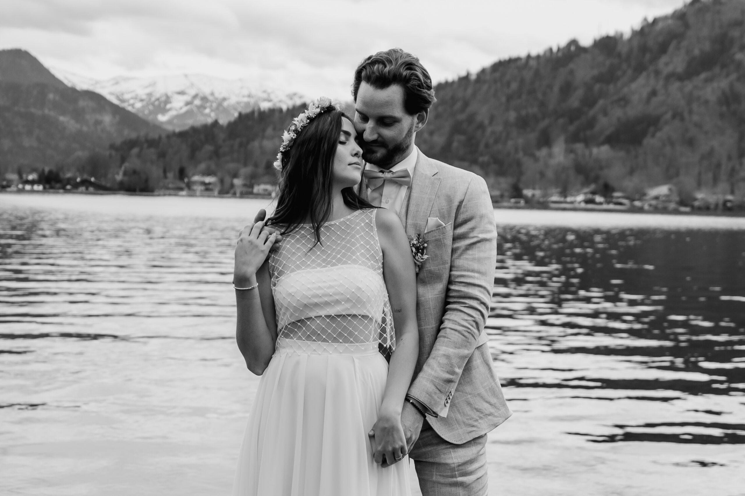 Schwarz-Weiß Bild, Braut und Bräutigam stehen verliebt vor dem Tegernsee