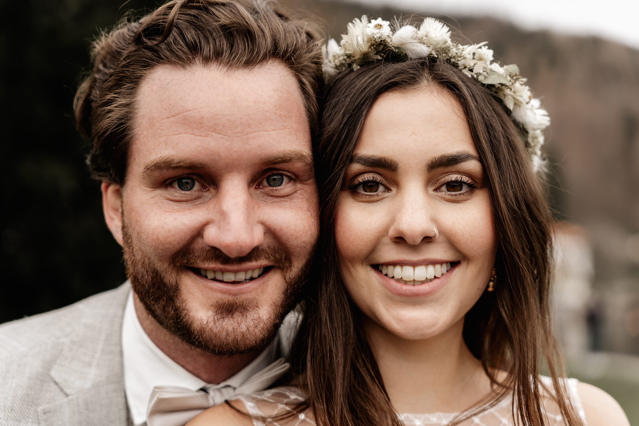 Portraitbild von Braut und Bräutigam, beide lachen in die Kamera