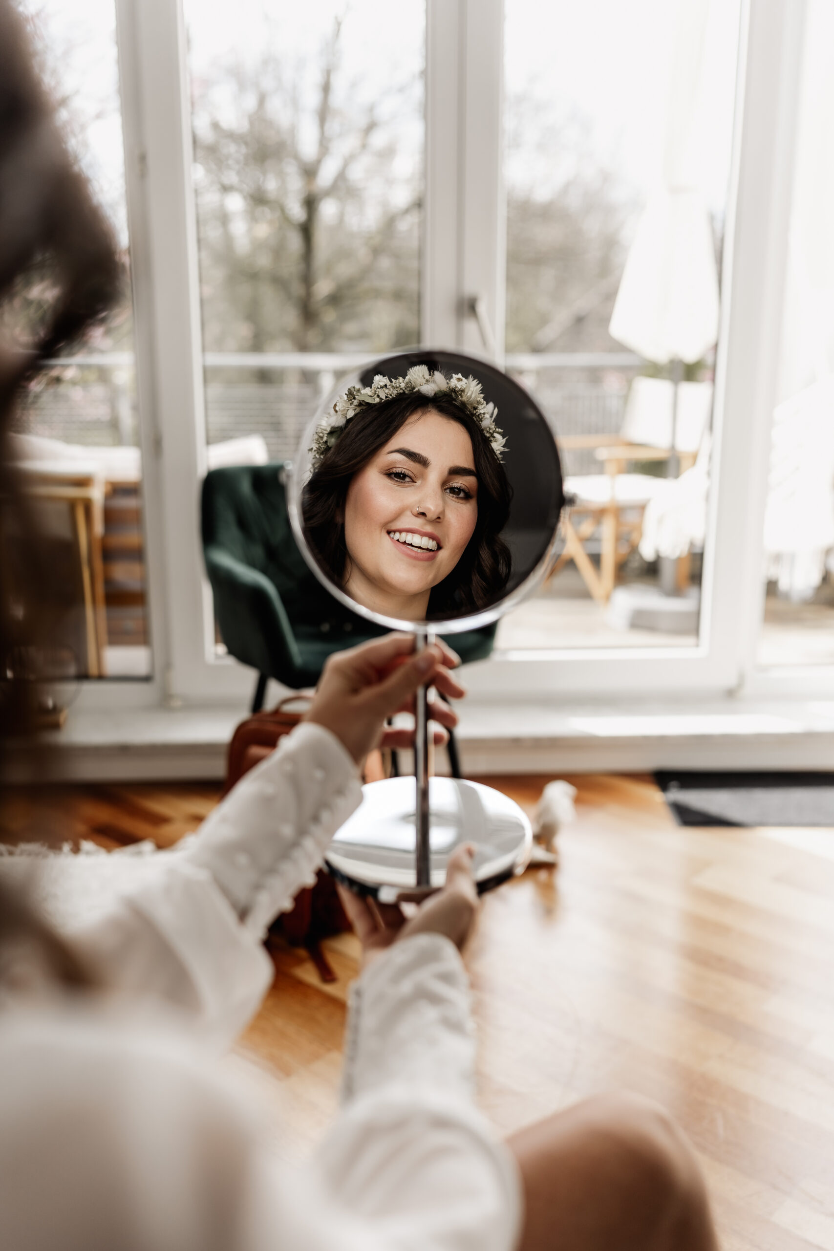 Braut betrachtet sich im Spiegel während Getting Ready, festgehalten von Hochzeitsfotograf Tegernsee
