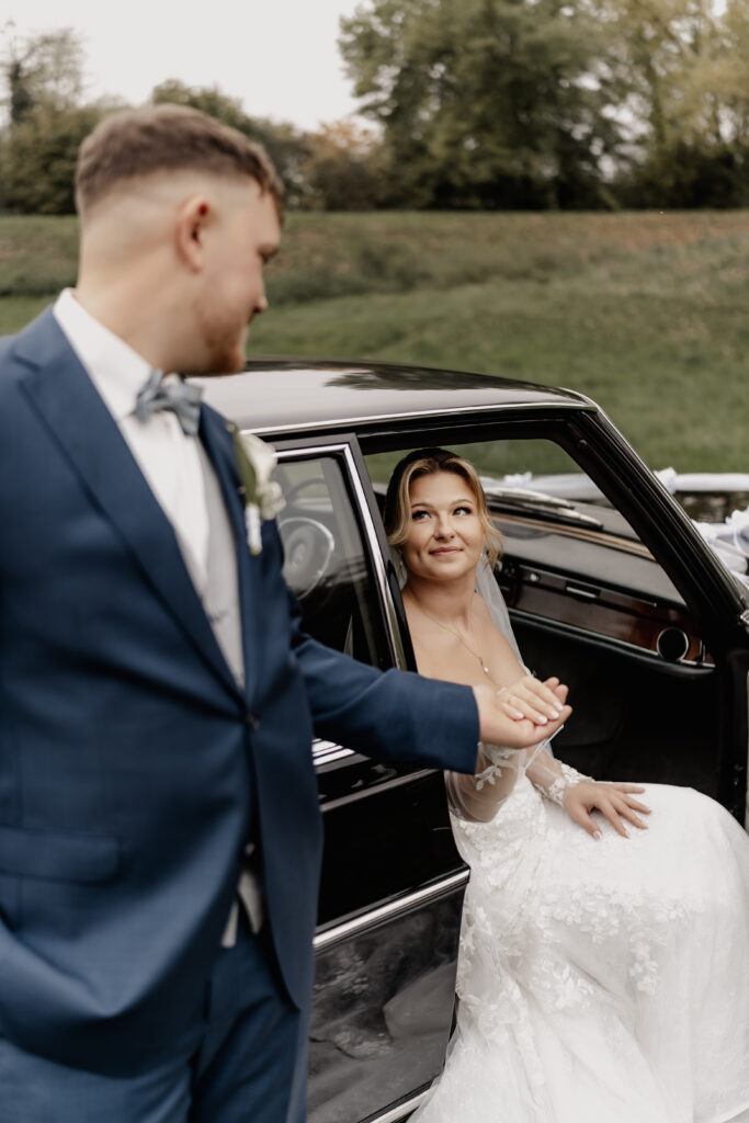 Bräutigam hilft Braut beim Aussteigen – Emotionale Hochzeitsfotos von Hochzeitsfotograf Frankfurt