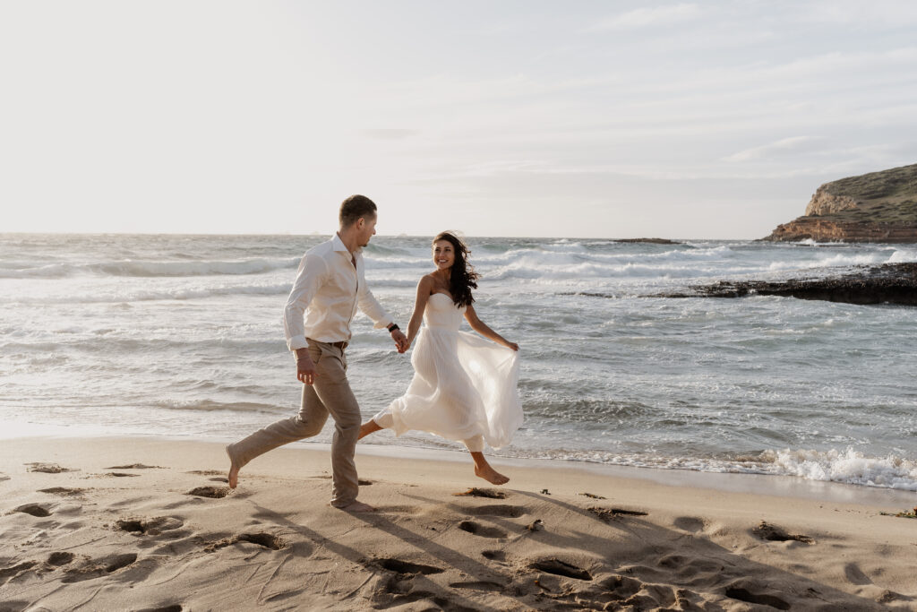 Braut springt beim Sunsetshooting am Strand, fröhlicher Moment – Ibiza Wedding Photographer