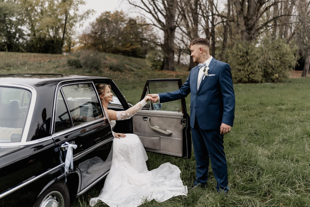 Braut steigt elegant aus Hochzeitsauto – Hochzeitsfotograf Frankfurt