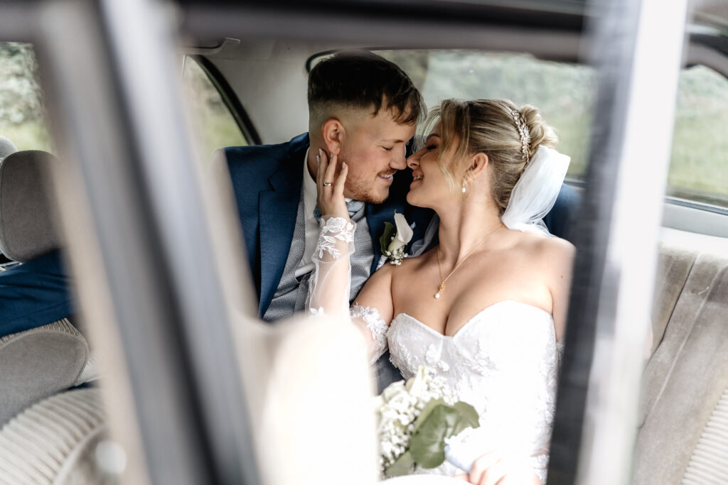 Braut und Bräutigam eng umschlungen im Auto. Hochzeitsfotograf Frankfurt