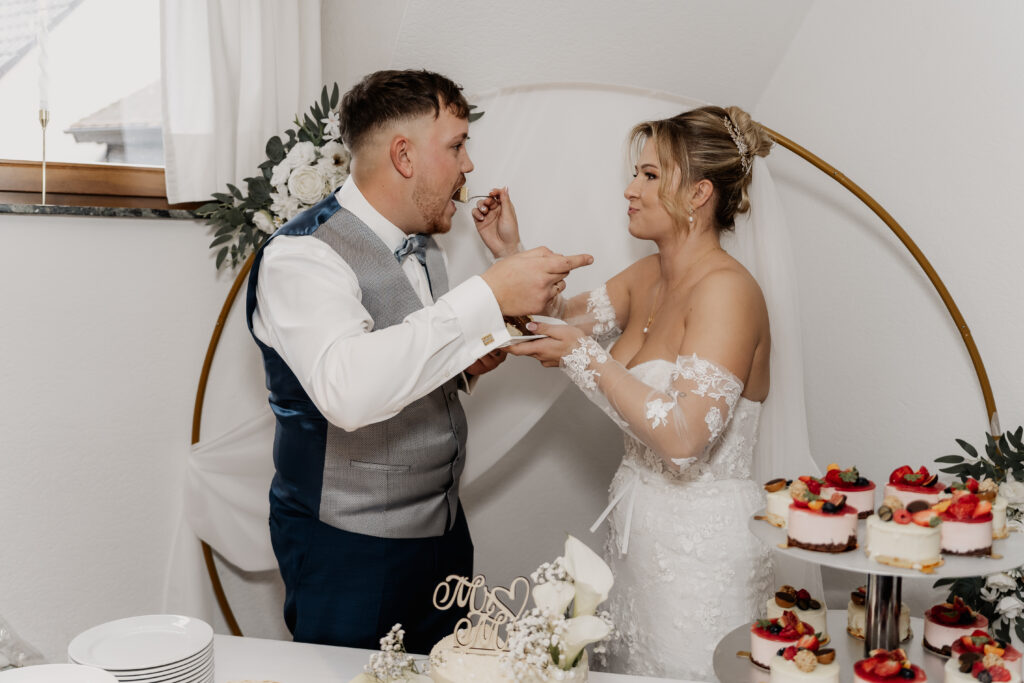 Braut und Bräutigam füttern sich gegenseitig ihre Hochzeitstorte im Restaurant Mönchshof Eddersheim