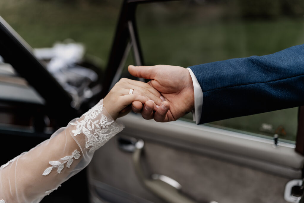 Detailaufnahme Händehaltendes Brautpaar im Hochzeitsauto – Hochzeitsfotograf Frankfurt