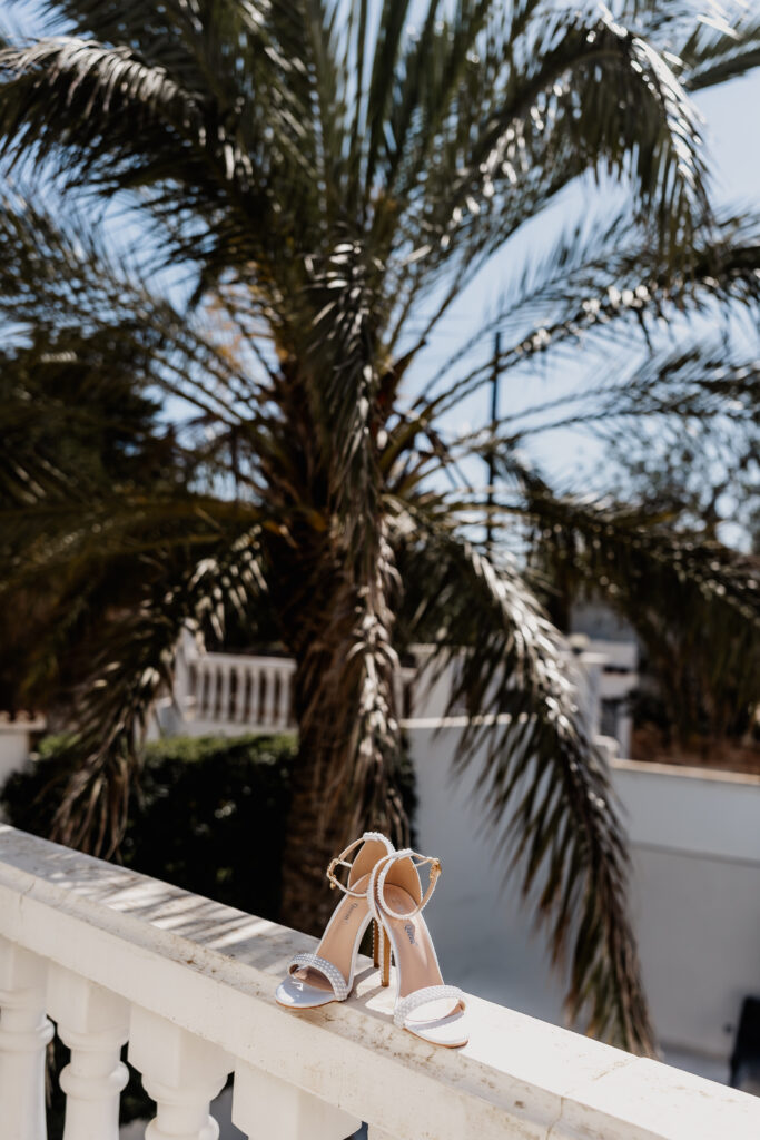 Elegante High Heels mit Perlen-Details mit Palmen im Hintergrund – mediterraner Ibiza Wedding Vibe
