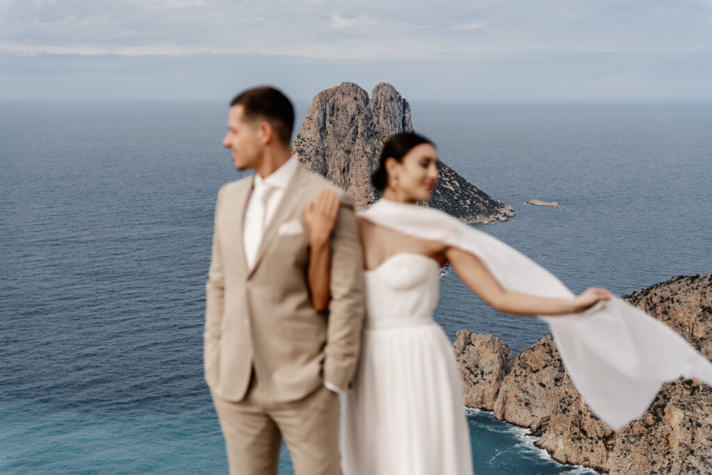 Es Vedrà im Fokus, Brautpaar im Hintergrund – Destination Wedding Photography