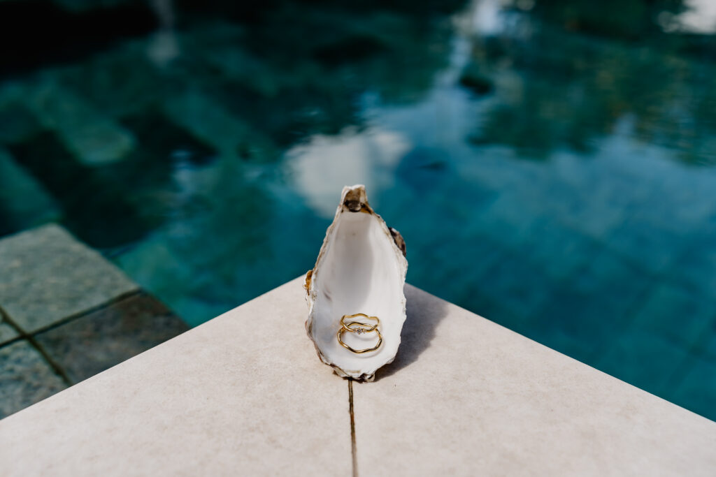 Goldene Eheringe in einer offenen Muschel am Pool – detailverliebte Aufnahme einer Ibiza Elopement Hochzeit