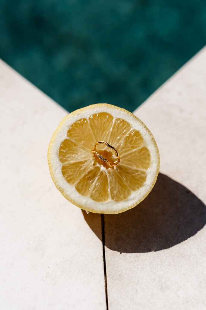 Goldring steckt in einer halben Zitrone am Poolrand – festgehalten von einem Ibiza Elopement Photographer