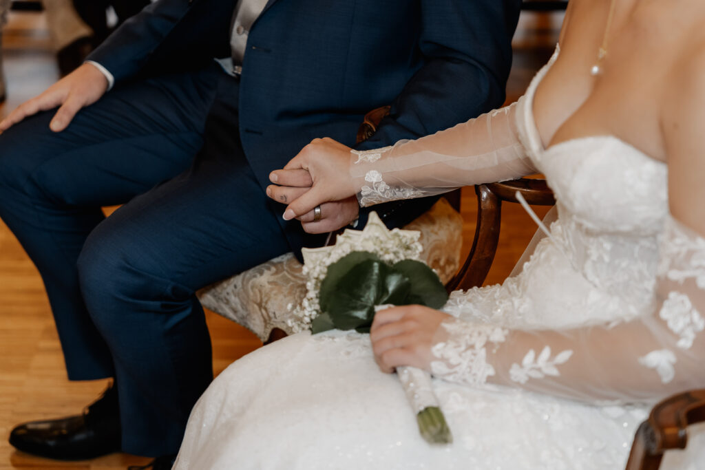 Detailaufnahme der ineinander verschlungenen Hände mit Eheringen während der Zeremonie. Hochzeitsfotograf Frankfurt