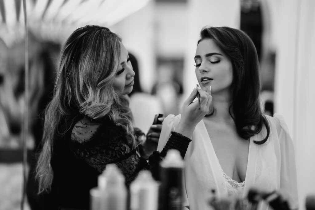 Hochzeitsfotograf München – Make-up im Roomers Hotel, Schwarz-Weiß-Porträt einer Braut beim Schminken