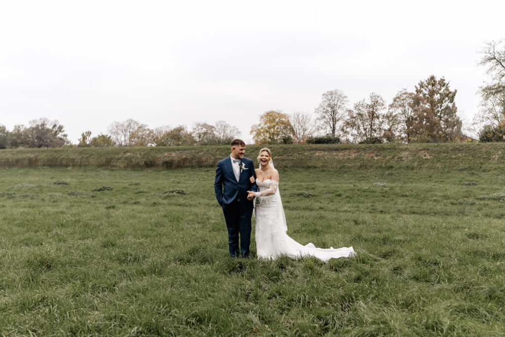 Lachendes Brautpaar in der Wiese. Hochzeitsfotograf Frankfurt, natürliche Hochzeitsfotos