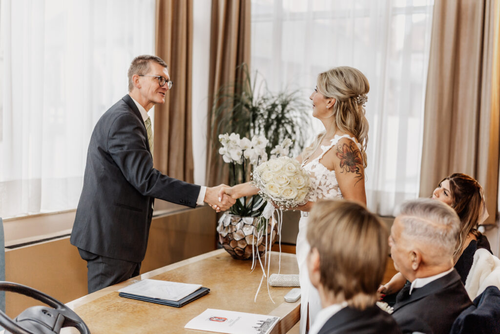 Braut reicht dem Standesbeamten die Hand im Standesamt Aschaffenburg - Hochzeitsfotograf Aschaffenburg