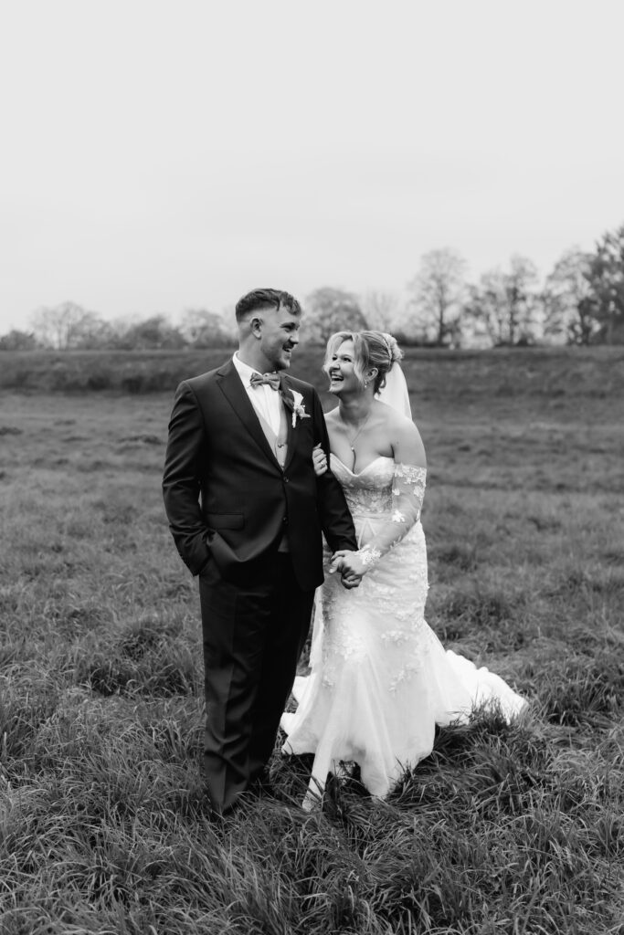 Schwarz-Weiß-Foto, Brautpaar lacht und hält sich an den Händen, Hochzeitsfotograf Frankfurt, Mönchshof Eddersheim