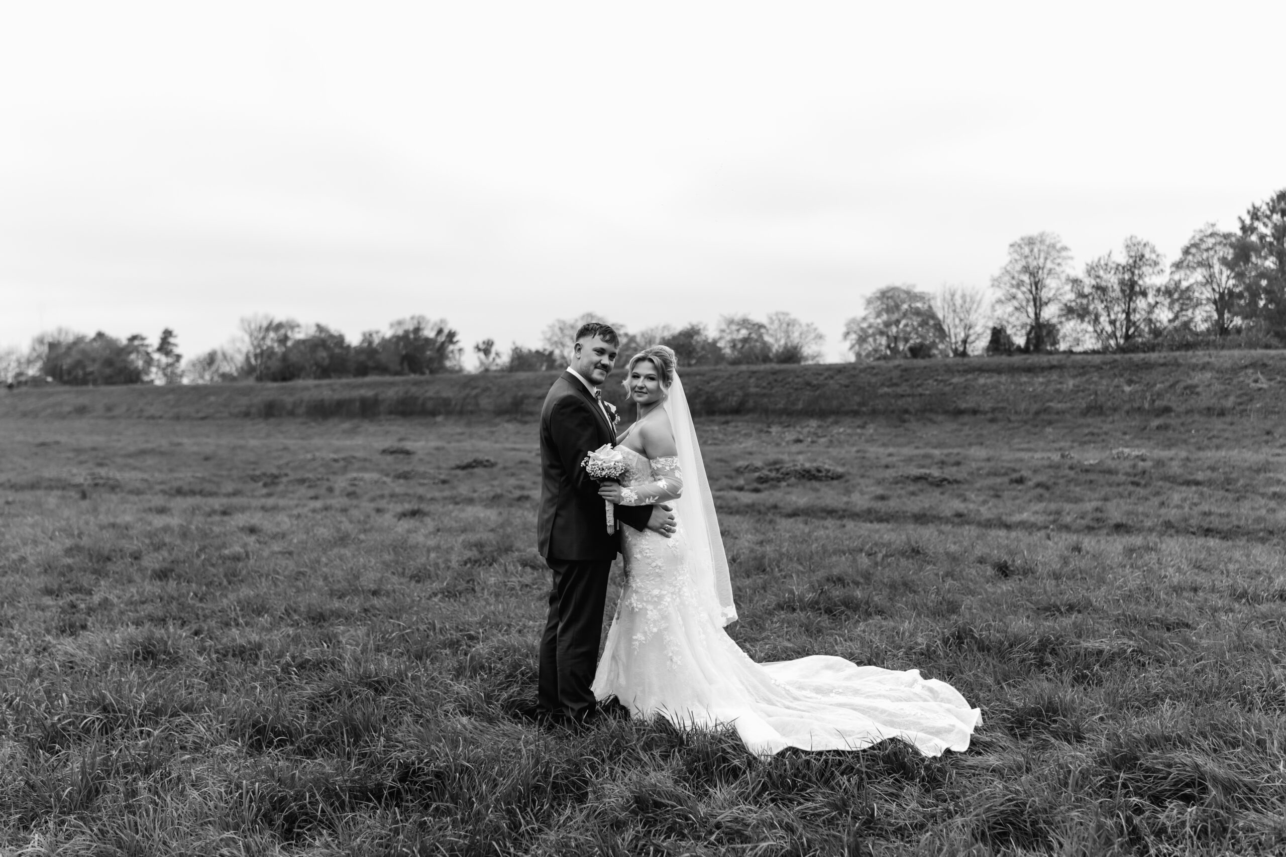 Schwarz-weiß Bild, Brautpaar steht sich innig auf Wiese gegenüber. Hochzeitsfotograf Frankfurt
