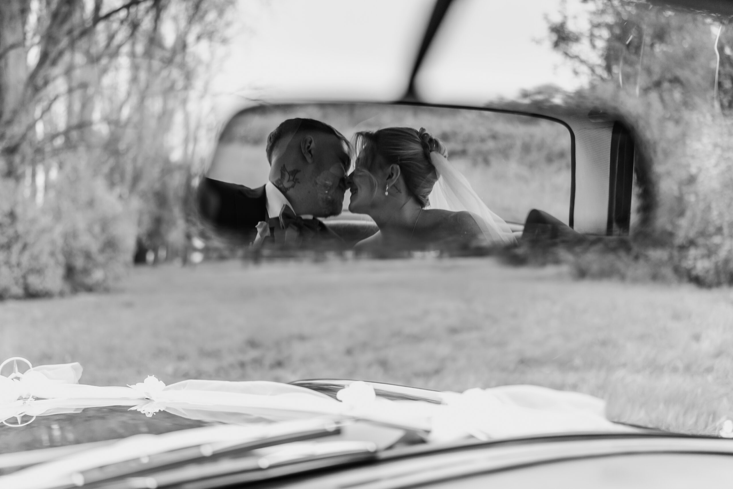 Spiegelbild des Brautpaares, das sich im Auto küsst, Hochzeitsfotograf Frankfurt
