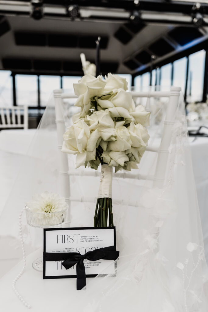 Strauß aus weißen Rosen an Chiavari-Stuhl – Hochzeitspapeterie in der Pyramide Mainz, Hochzeitsfotograf Mainz