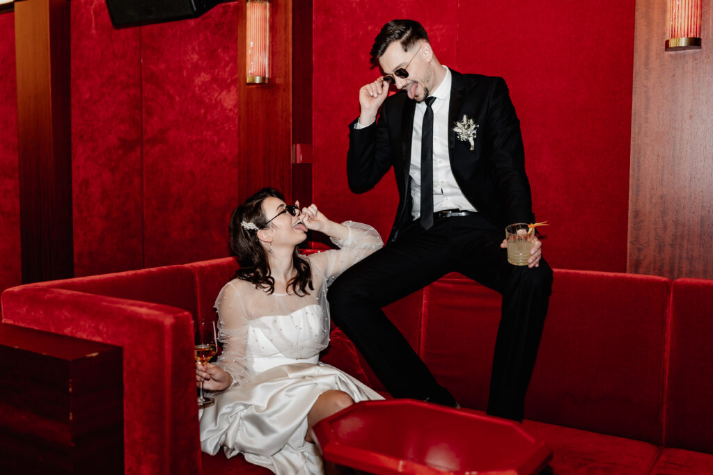 Verspielter Moment im Roomers Hotel München– Brautpaar mit Sonnenbrillen - Hochzeitsfotograf München