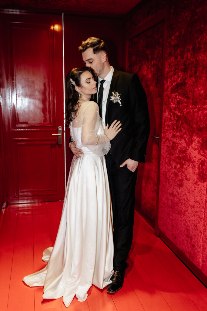 Zärtlicher Moment im Roomers Hotel München – elegante Hochzeitsfotografie mit Stil und Emotion