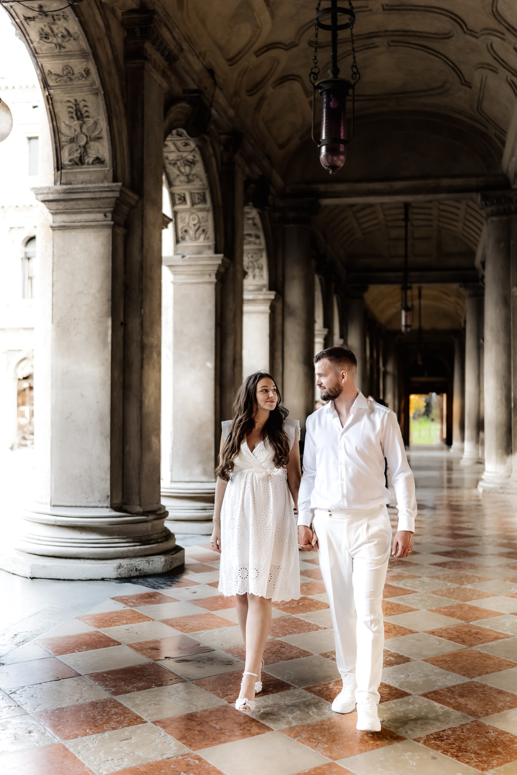 Braut und Bräutigam laufen Hand in Hand beim Markusplatz in Venedig