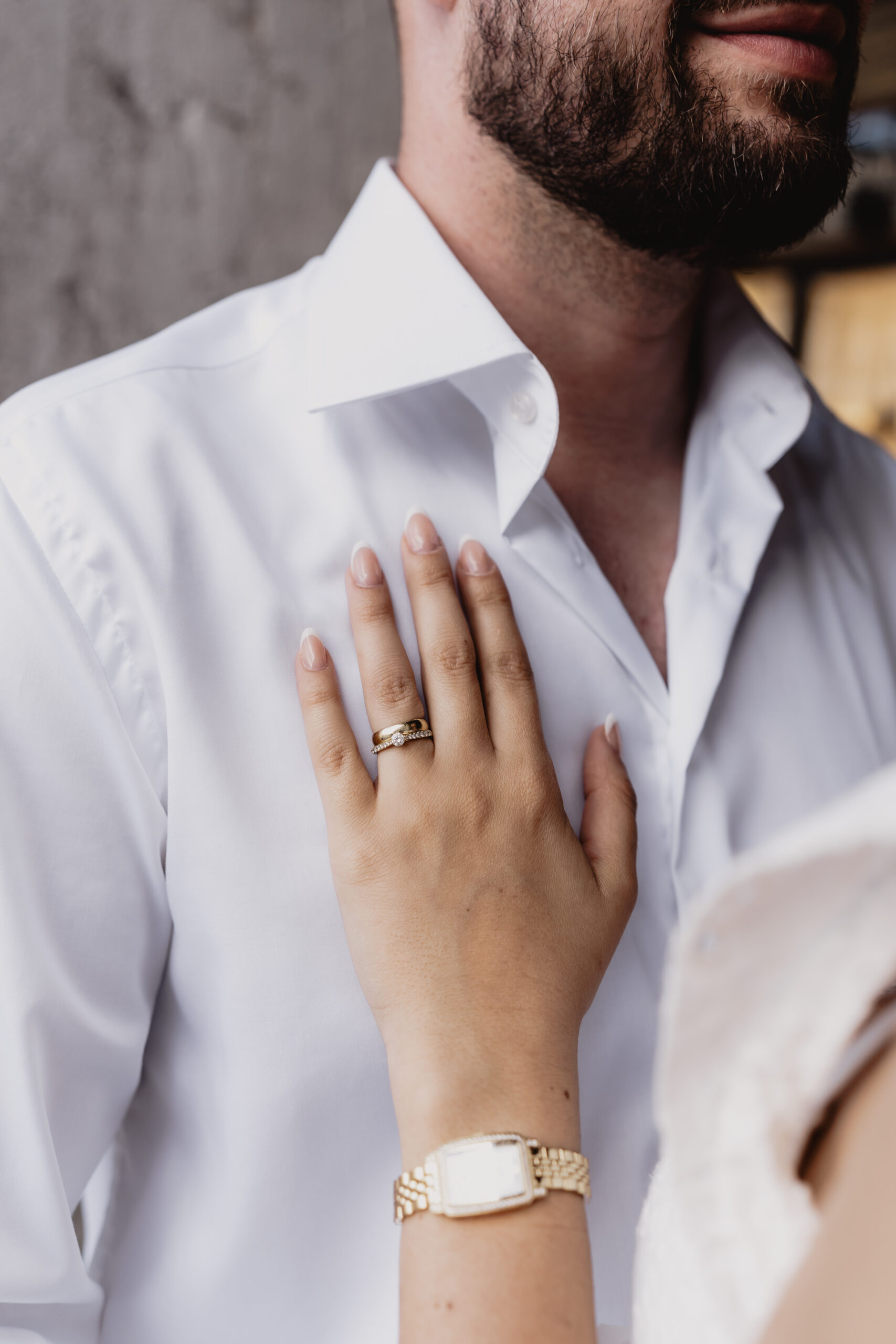 Detailbild von Ring der Braut, Hand liegt auf der Brust des Bräutigams