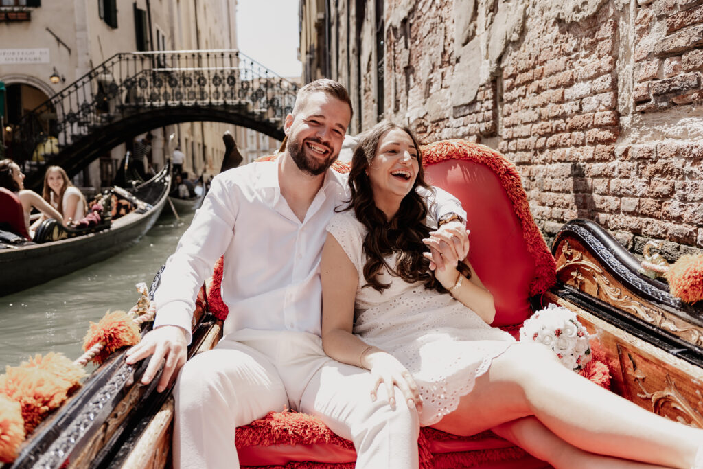 Brautpaar lachend während Gondelfahrt in Venedig, Hochzeitsfotograf Venedig