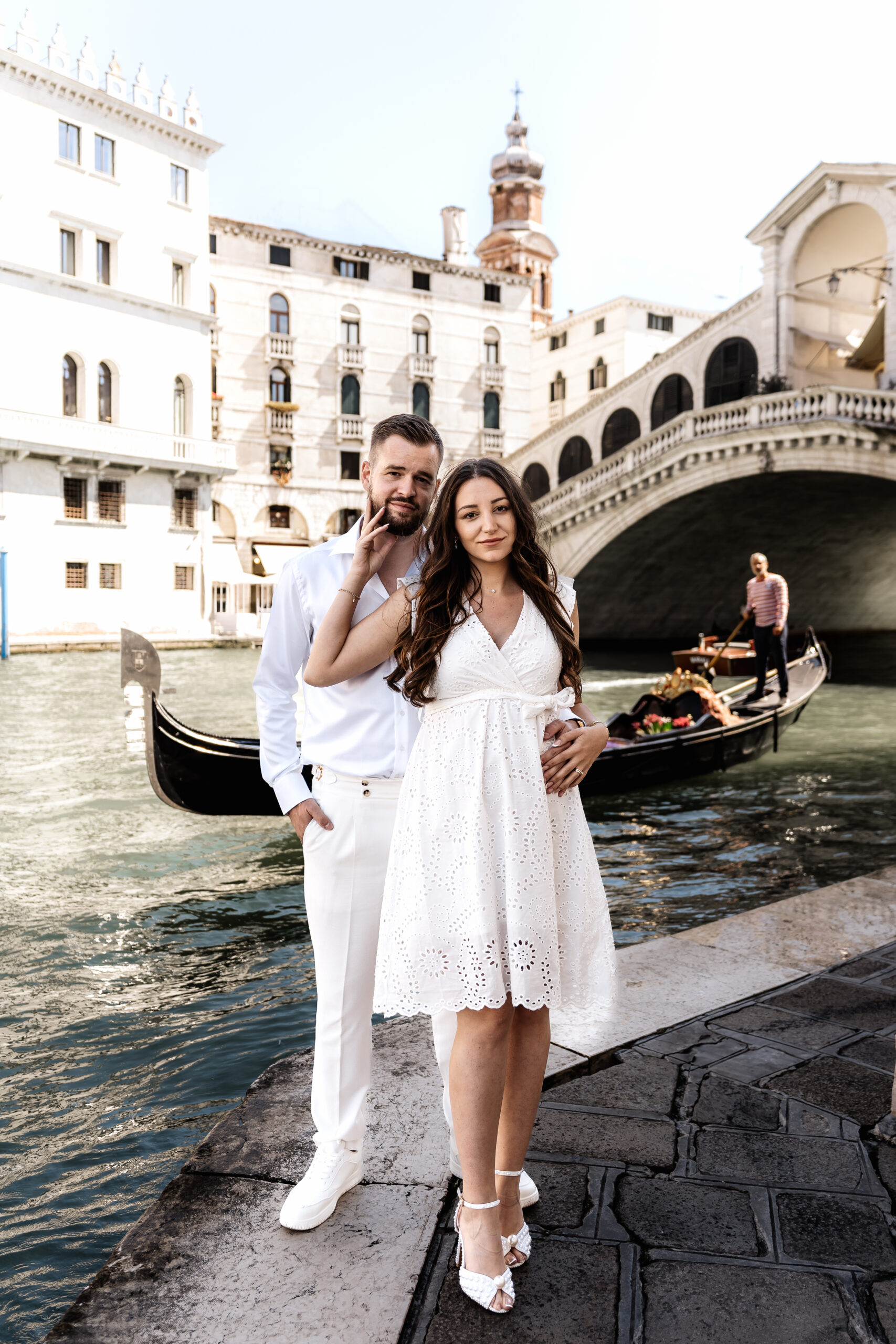 Brautpaar steht vor der Rialto Brücke in Venedig und schaut in die Kamera