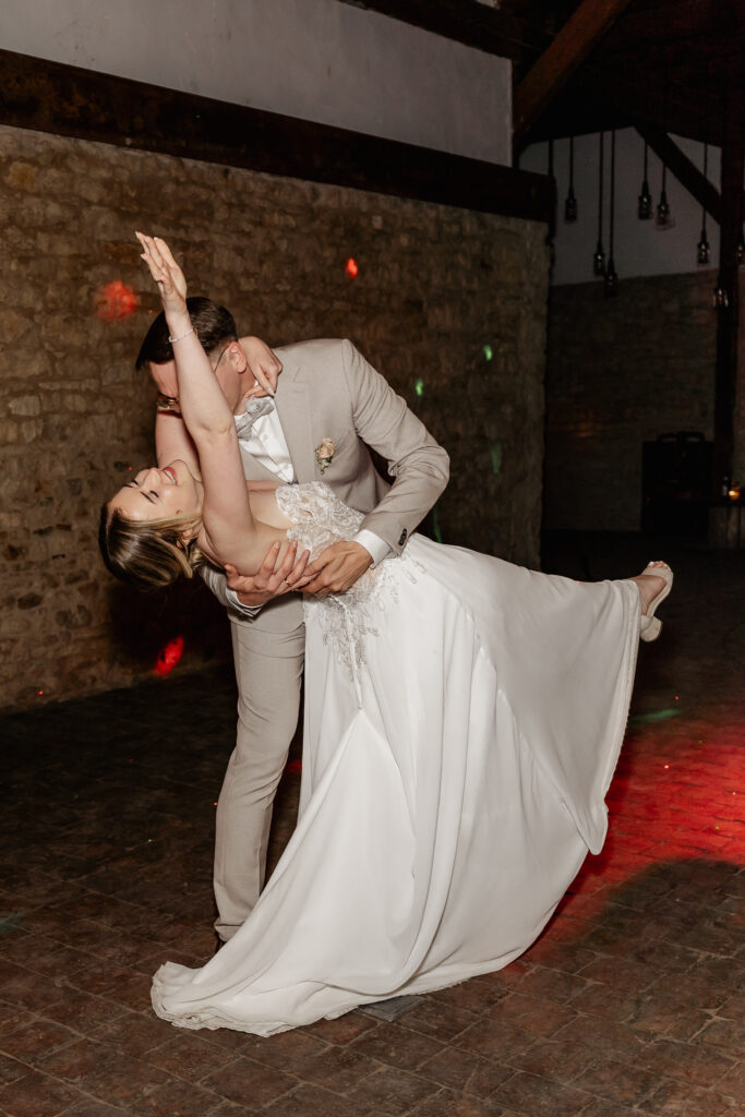 Bräutigam dippt die Braut beim Hochzeitstanz, fließendes Brautkleid in Bewegung