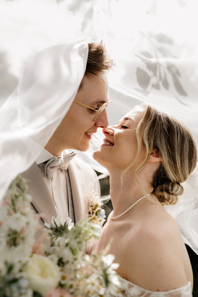 Nahaufnahme vom Brautpaar unter dem Schleier, intime Hochzeitsfotografie