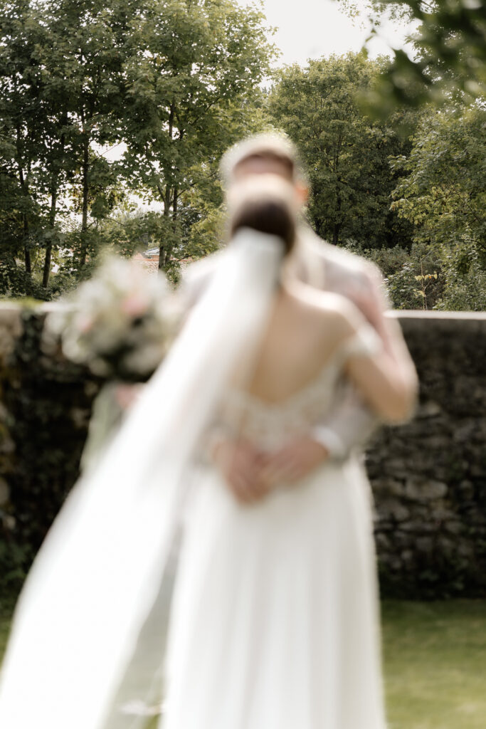 Hochzeitspaar umarmt sich nach dem First Look im Garten der Eventlocation BourdierKoeller Stetten