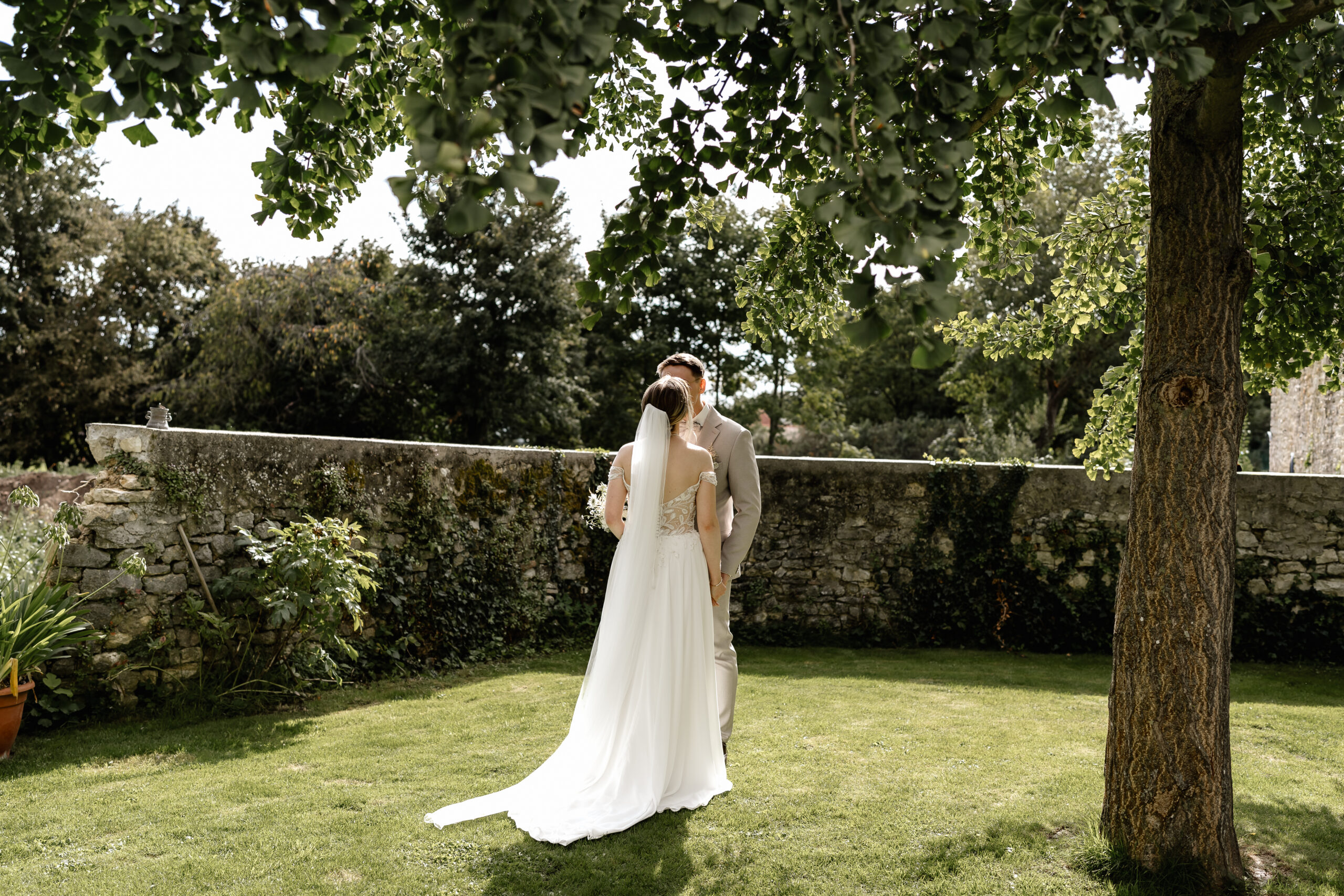 Braut und Bräutigam stehen sich im Garten gegenüber, romantisches Paarshooting BourdierKoeller Stetten