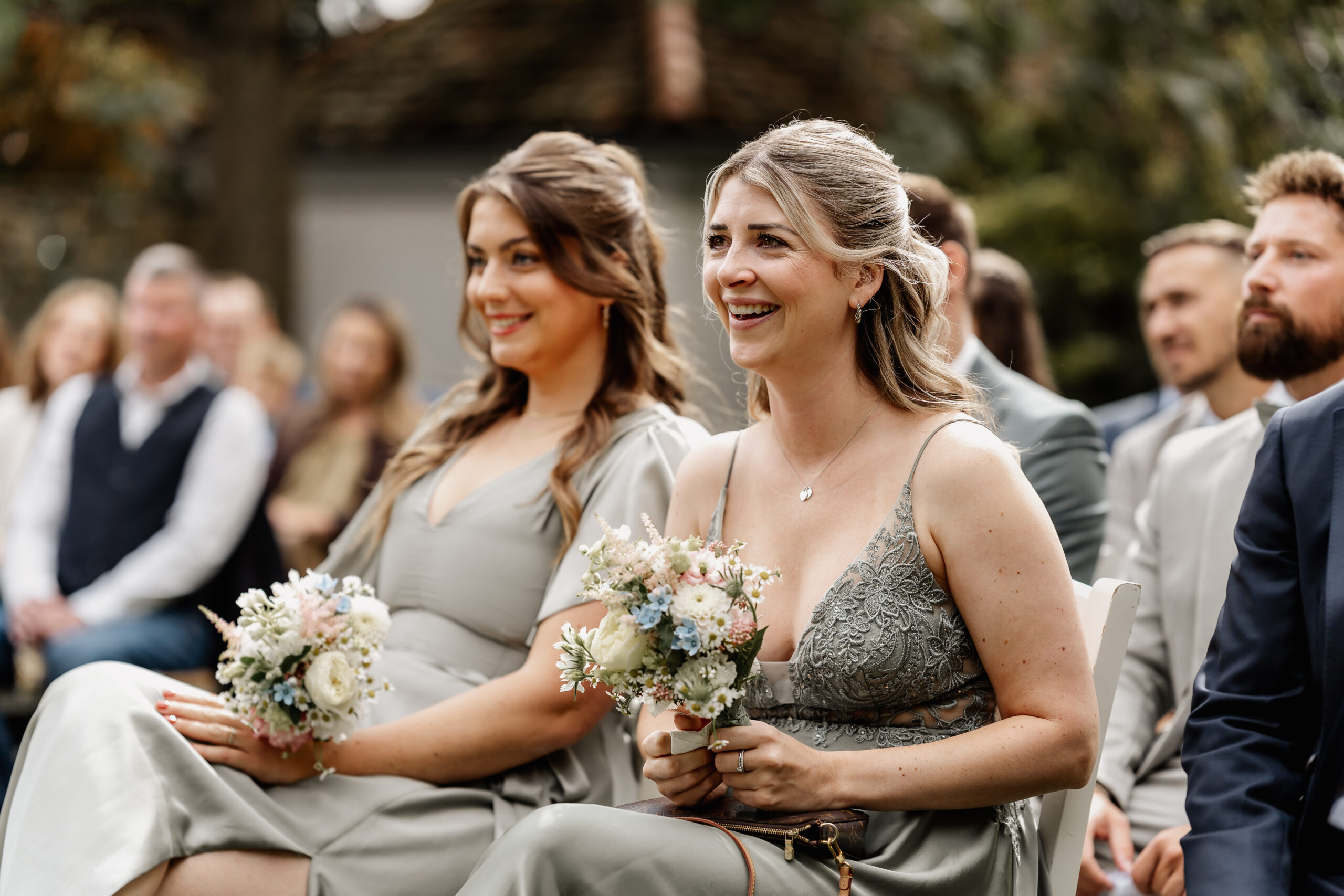 Brautjungfern sitzen lächelnd während der Trauung, emotionale Hochzeitsreportage