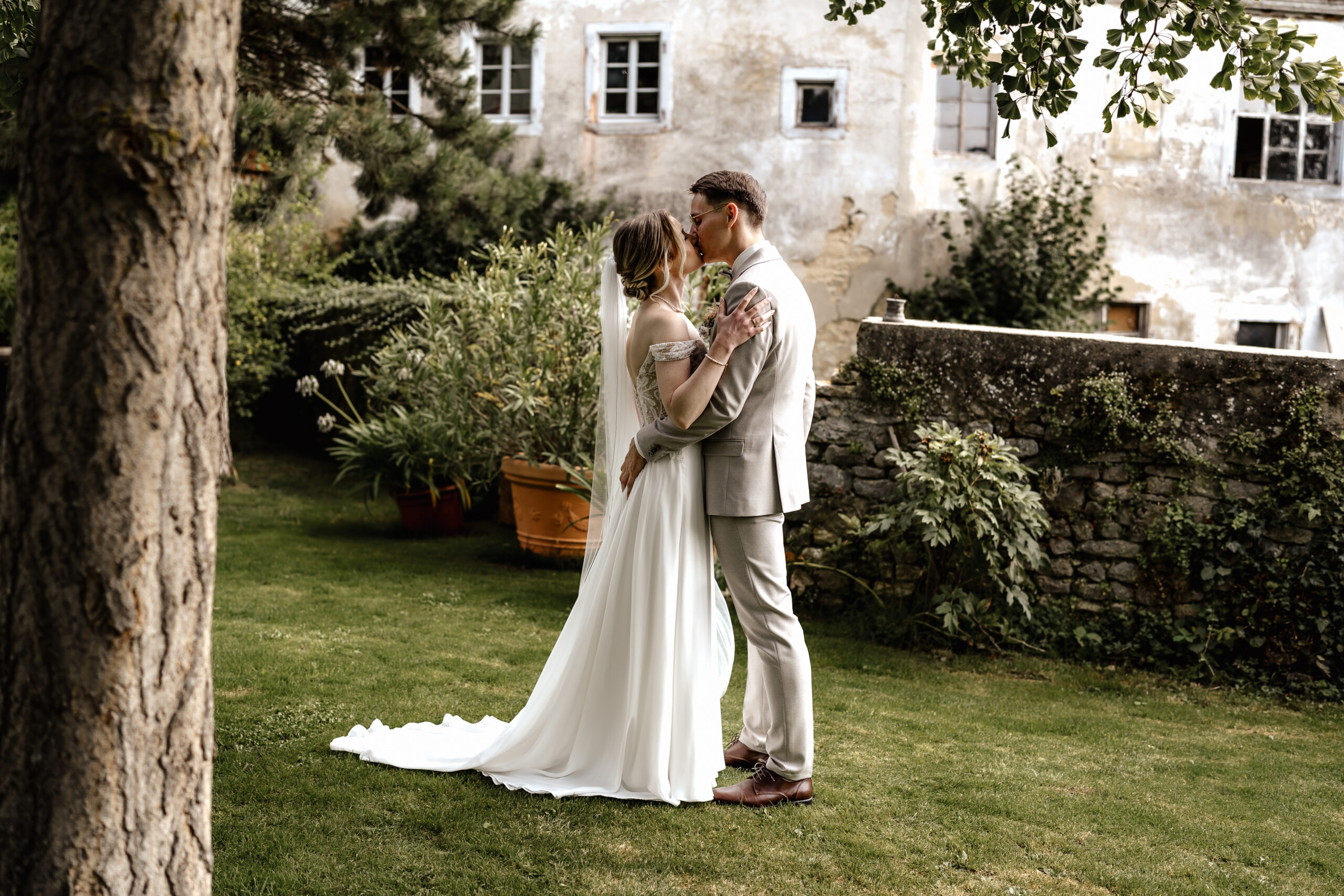 Hochzeitspaar küsst sich im Grünen, natürliches Paarshooting in der Eventlocation BourdierKoeller Stetten