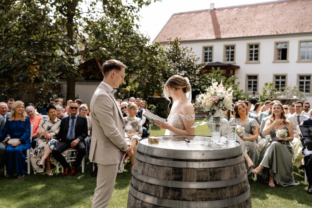 Braut liest ihr Eheversprechen vor, freie Trauung im Garten der Eventlocation BourdierKoeller
