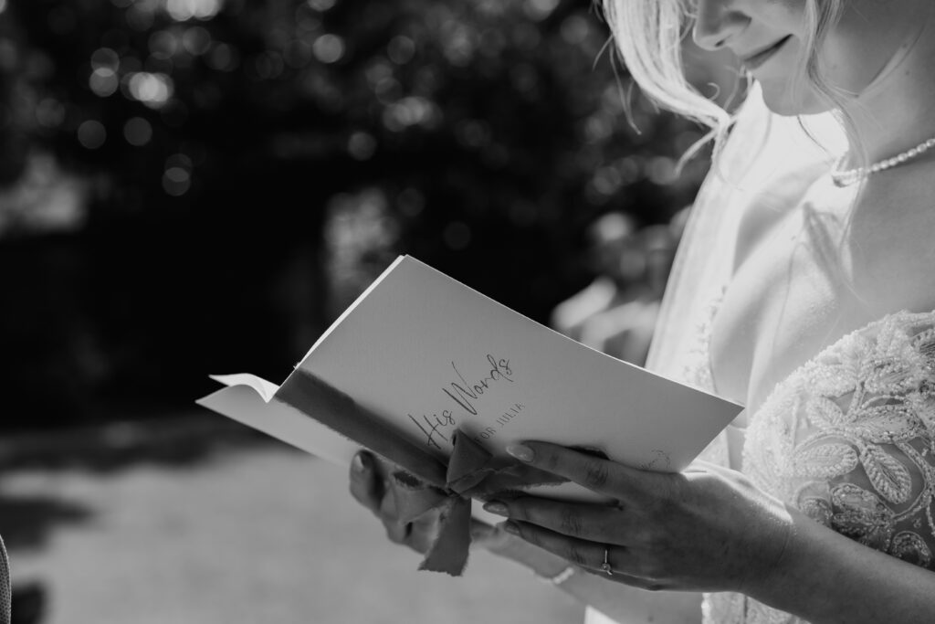 Schwarzweißfoto: Braut liest emotionale Worte bei der freien Trauung