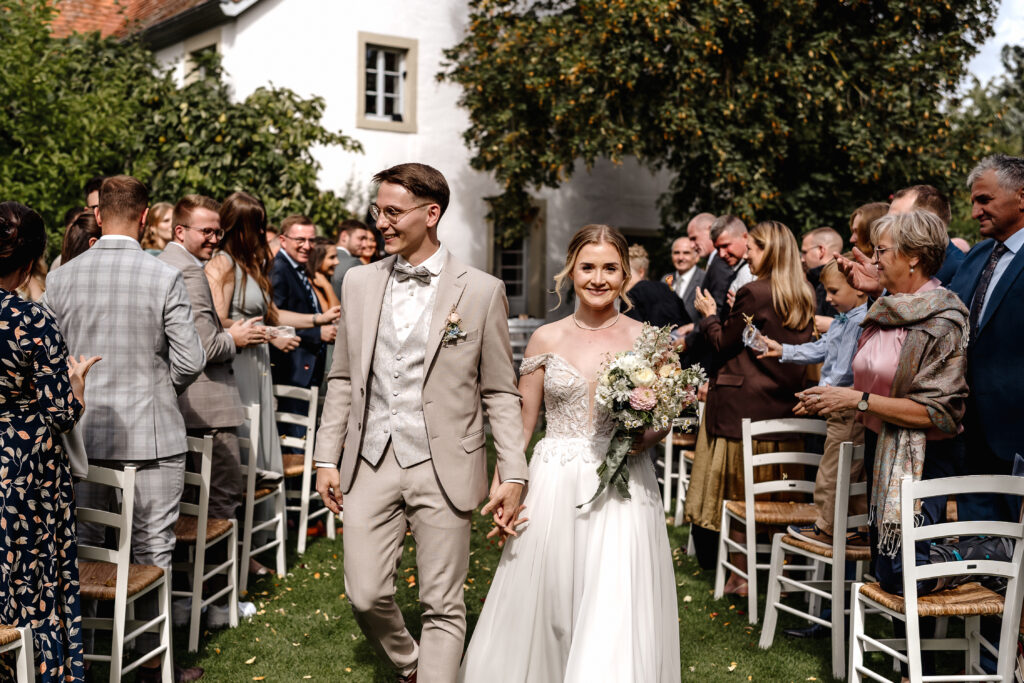 Auszug des Brautpaars durch die Gäste nach der Trauung