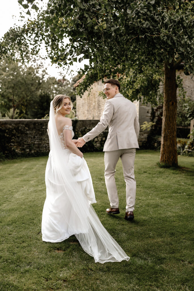 Brautpaar geht Hand in Hand durch den Garten, Paarshooting in der Eventlocation BourdierKoeller Stetten