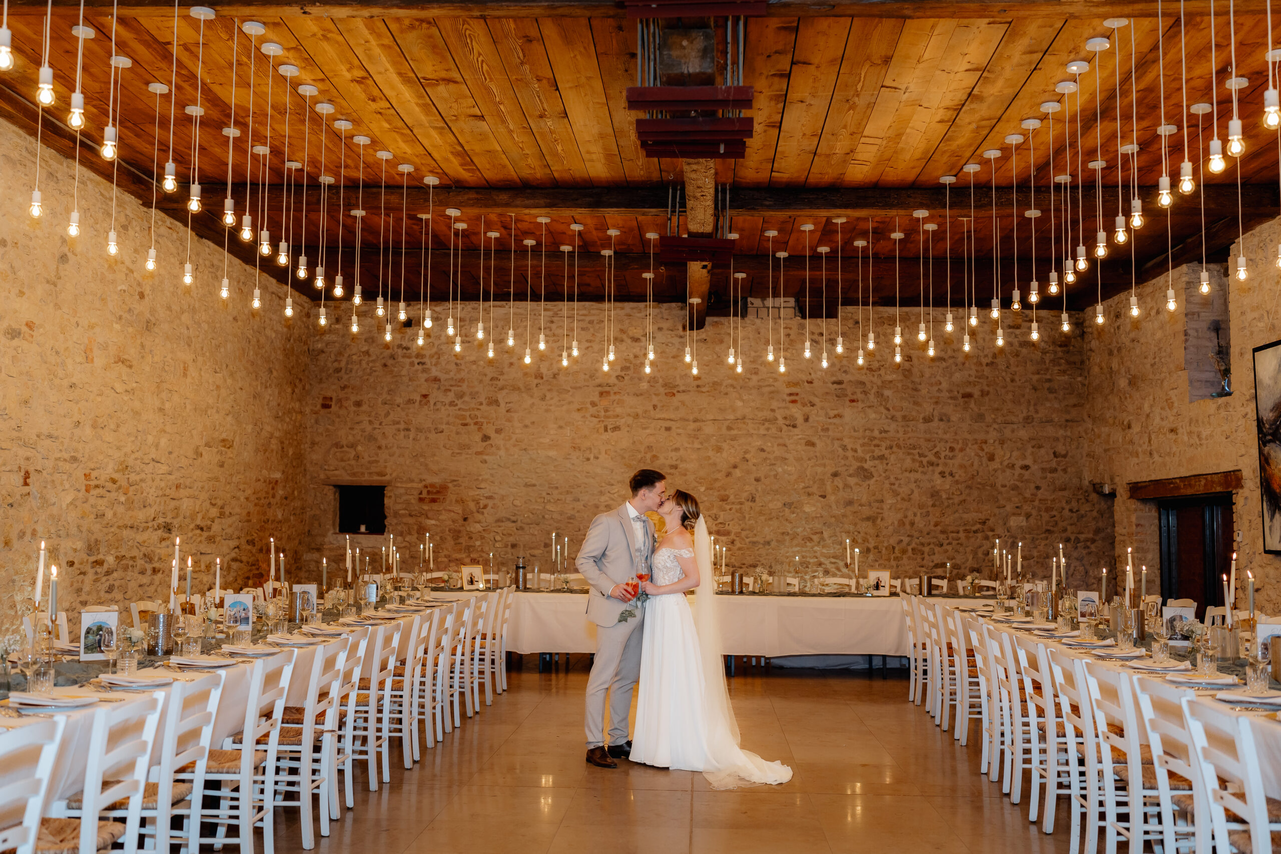Brautpaar steht zwischen festlich gedeckten Tischen, Hochzeitsreportage BourdierKoeller Stetten
