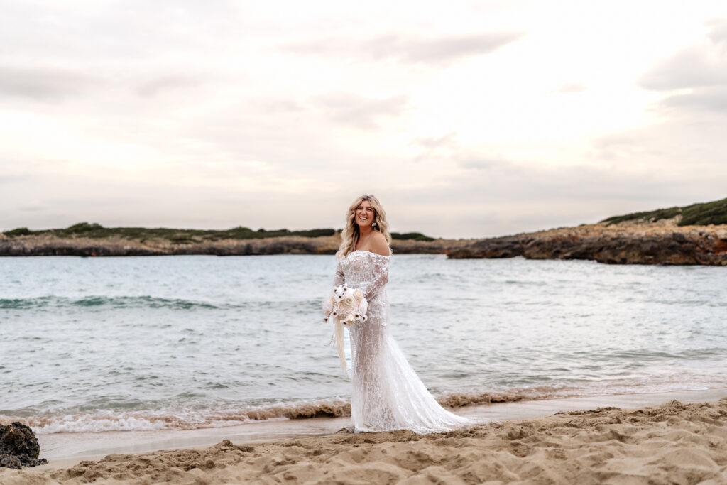 Braut lacht glücklich während dem Sonnenuntergang am Strand von Mallorca, After-Wedding-Shooting Mallorca