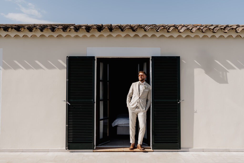 Bräutigam im Hochzeitsanzug vor der Tür im Vino Resort Son Amaret auf Mallorca