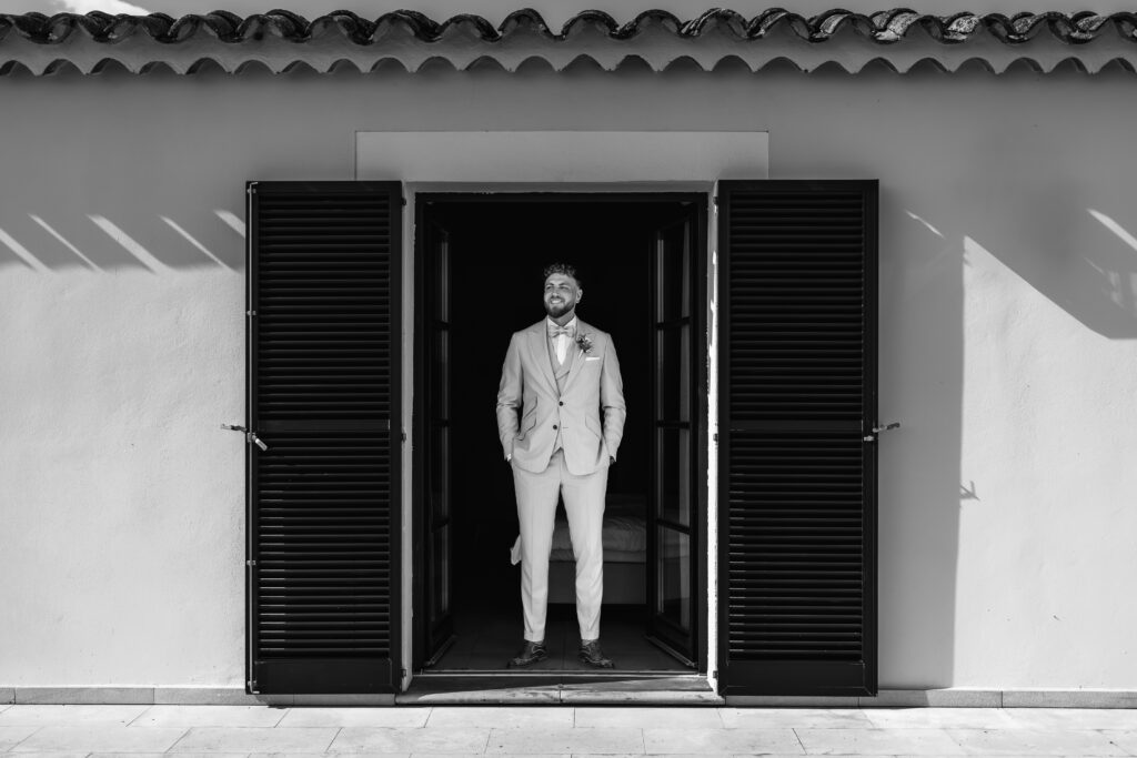 Schwarzweiß Portrait des Bräutigams im Türrahmen bei Mallorca Hochzeit