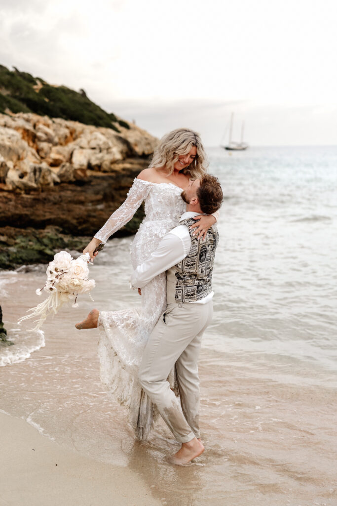 After-Wedding-Shooting am Strand von Mallorca, Brautpaar lacht und dreht sich am Strand