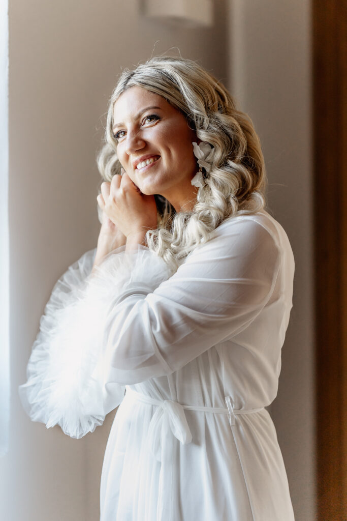 Braut beim Getting Ready mit Ohrringen im natürlichen Licht auf Mallorca