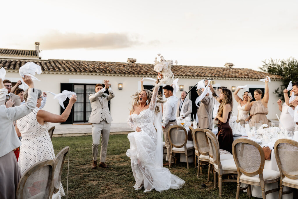 Ausgelassener Hochzeitseinlauf: Brautpaar tanzt lachend durch die Dinner-Tische