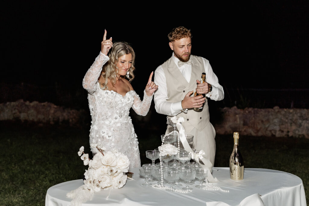 Glückliches Brautpaar feiert den Sektturm mit Spaß und Emotion