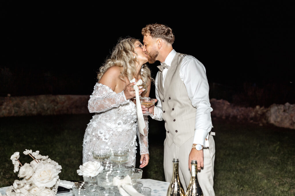 Brautpaar küsst sich beim befüllen des Sektturms am Abend