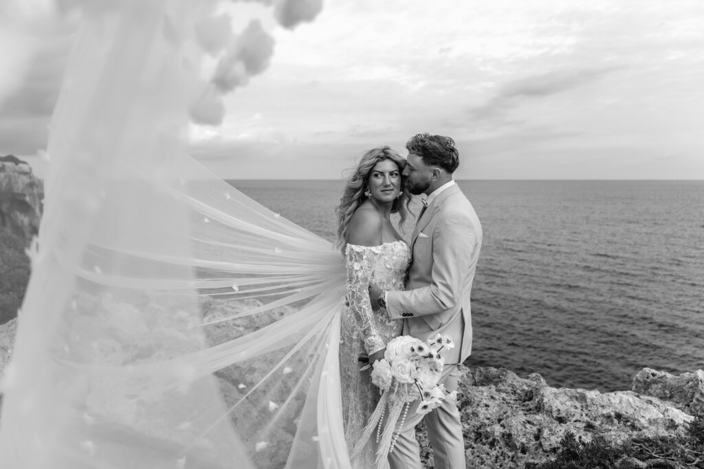 Hochzeitspaar bei After-Wedding-Shooting an felsiger Küste auf Mallorca in Schwarz-Weiß