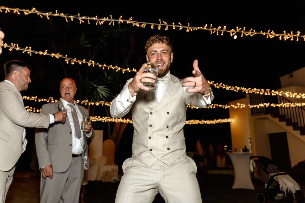 Bräutigam tanzt ausgelassen mit Getränk in der Hand während der Hochzeit auf Mallorca